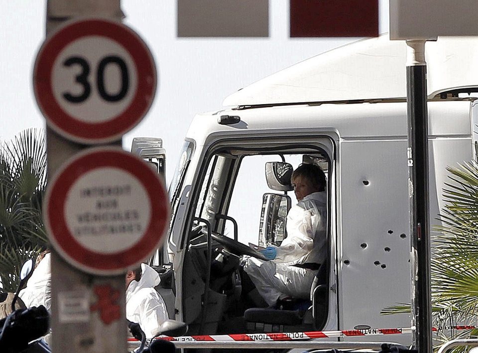  Investigators inspect the bullet-riddled cabin of the truck after police fired on the vehicle in a desperate bid to stop the driver