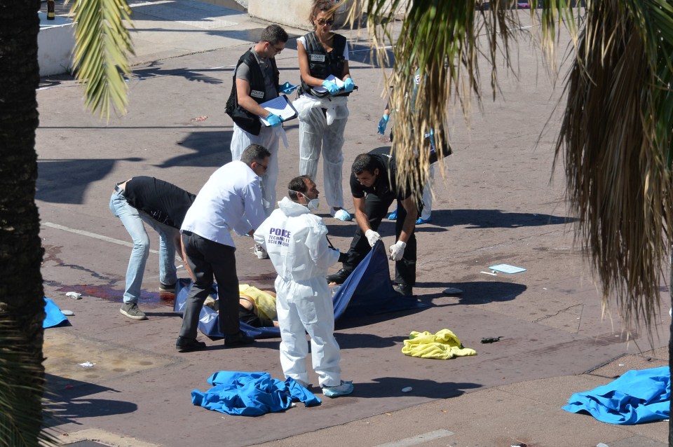  Forensics work at the scene this morning, while bodies still lay covered on the promenade