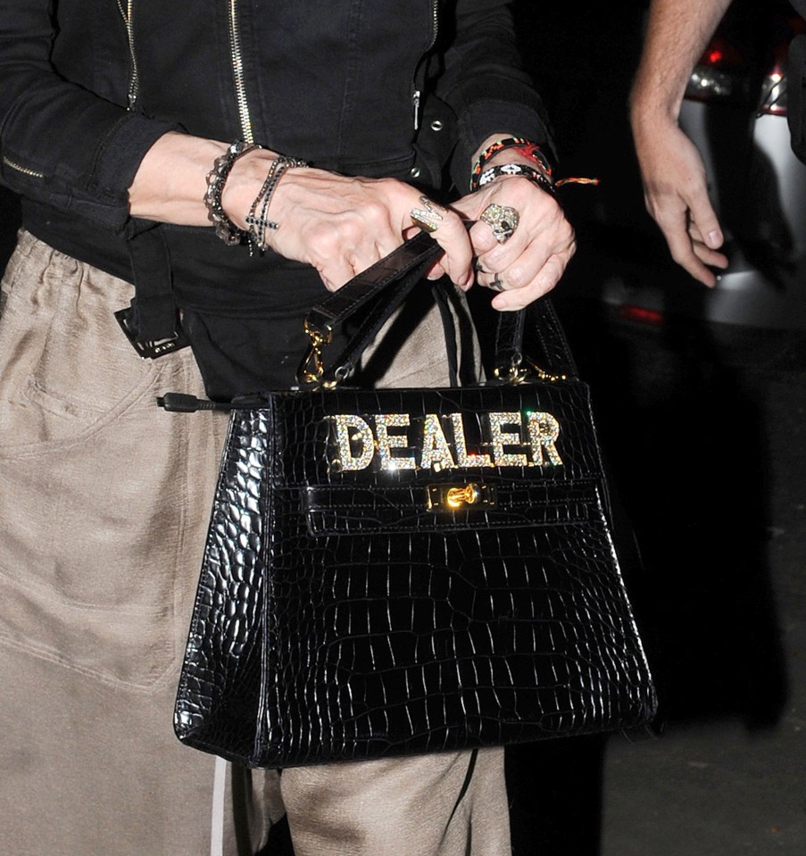  She carried a black bag with the phrase 'dealer'