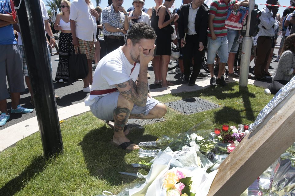  Tears for victims... a mourner weeps as people lay flowers at the site where a truck terrorist killed 84 people after he drove into a crowd on the Promenade des Anglais in Nice