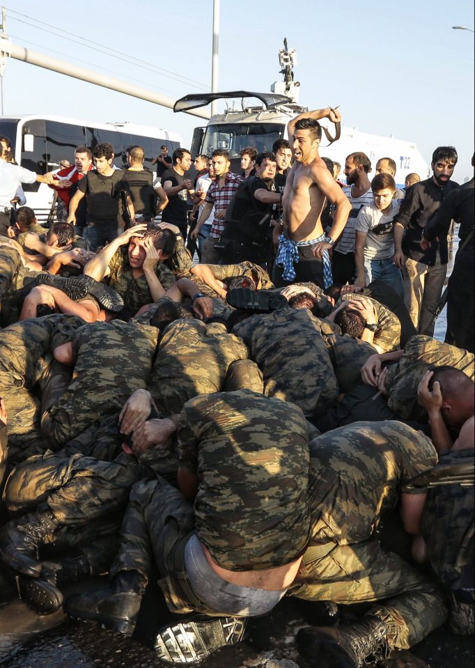  An unidentified man uses his belt to hit Turkish soldiers involved in the coup attempt that have now surrendered on Bosphorus bridge