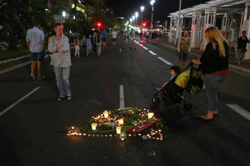  Candles light up a floral tribute in the spot where a person died during the attack last Thursday