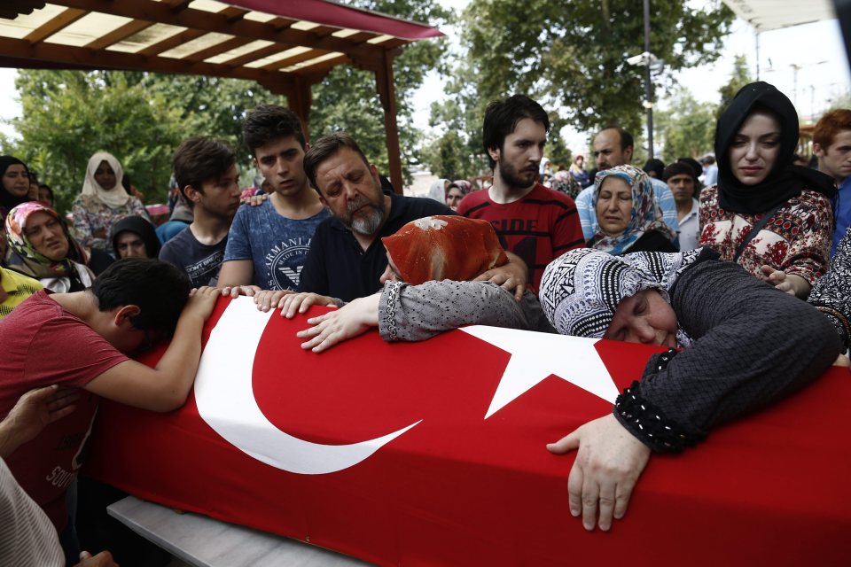  A boy holds on to the coffin of his father who was one of the 265 people killed during the attempted coup in Turkey on Friday