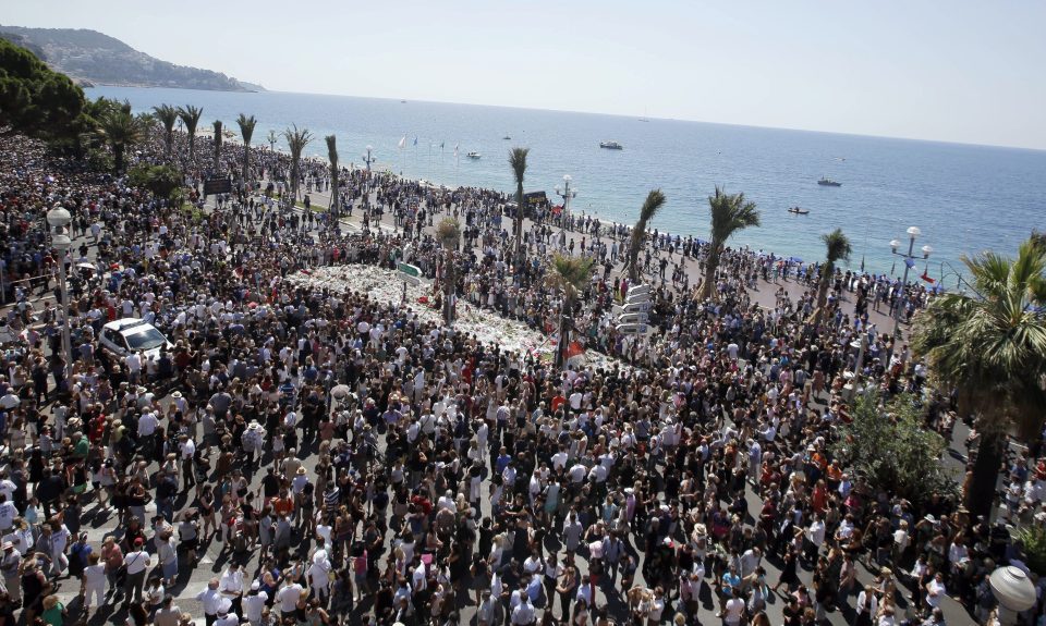  Honouring the dead... thousands gather at a makeshift memorial to observe a minute's to the Bastille Day massacre victims on the Promenade des Anglais in Nice