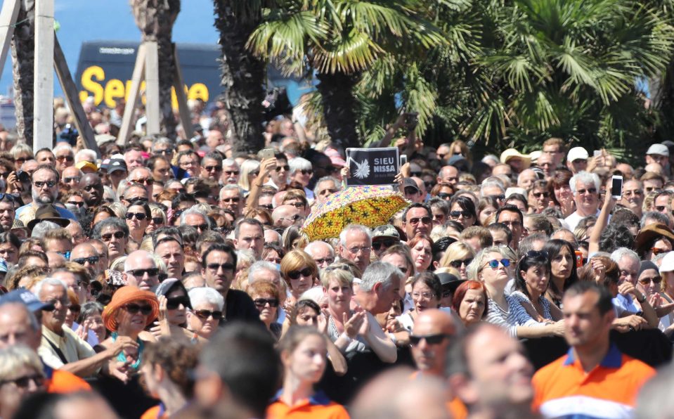  A man holds a placard reading "I am Nice" as people gather to observe a minute's silence on the Promenade des Anglais seafront in Nice