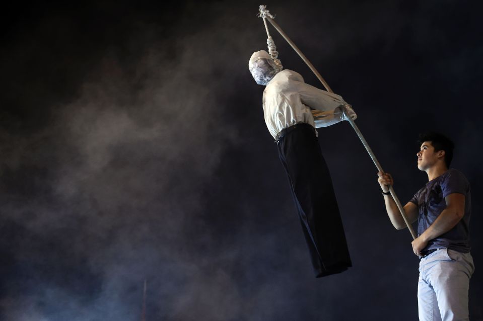  The dummy is hanged with a noose around its neck in front of dozens of supporters