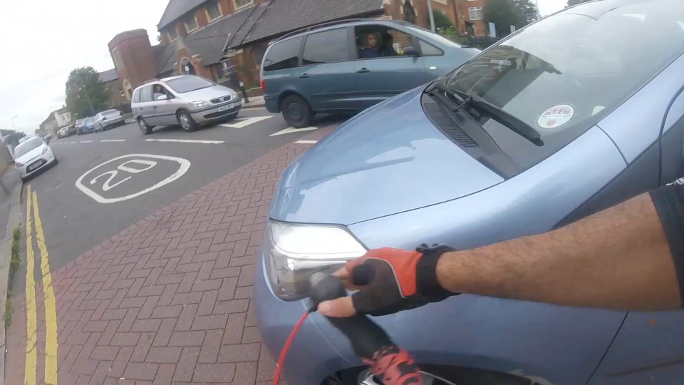  He crashes into the front left wing of the car as shocked drivers look on