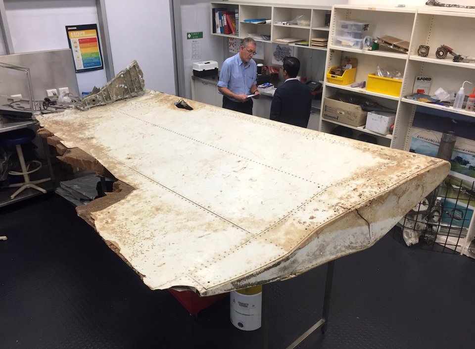  Australian and Malaysian officials examine aircraft debris at the Australian Transport Safety Bureau headquarters in Canberra