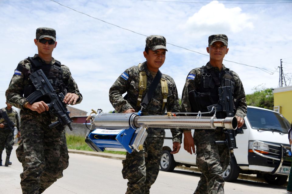  Honduran police carry a large Zika fumigation device