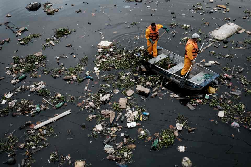  Workers attempt to clean the filthy sewage of the official Olympic venue