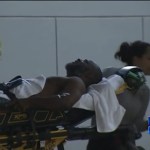  Mr Kinsey is taken to hospital on a stretcher after being shot in the leg