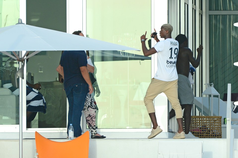  Paul Pogba, wearing a T-shirt with his own name and number on the back, looks to be explaining his actions to agent Raiola away from the party in Miami