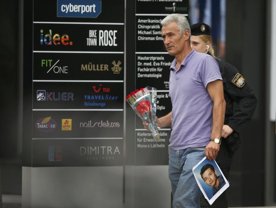  A grieving father carries flowers and a photo of his son who was killed by Sonboly