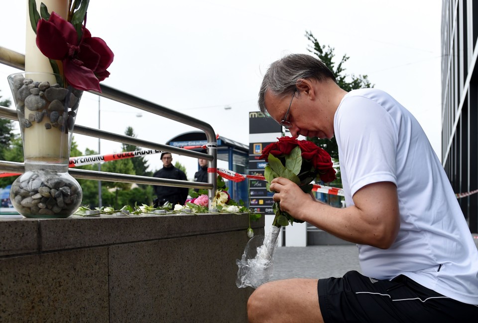  A man pays his respects near to the mall where nine people were killed by the 'deranged' gunman