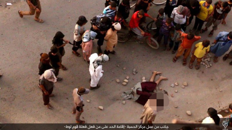  ISIS thugs stone a gay man's body even though he is already dead - as young kids watch on