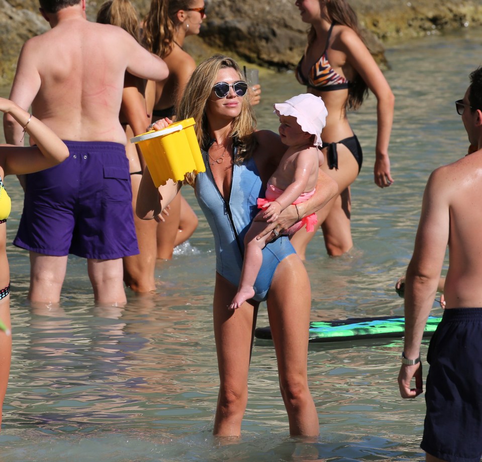  The model displayed her enviable figure in the sky blue swimming costume, while attending to her one-year-old daughter Liberty