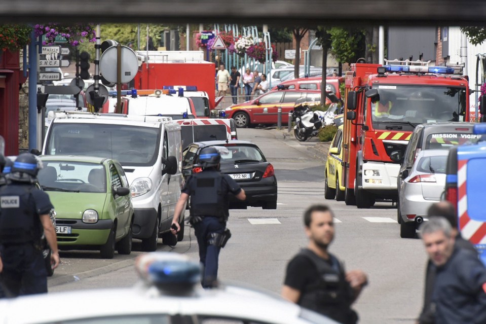  Police and rescue workers stand at the scene after the two assailants were shot and killed