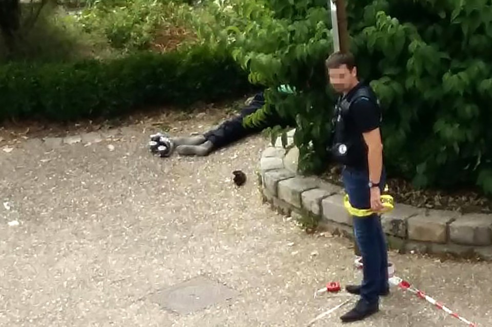 A policeman cordons the site next to the body of one of the two men who stormed the church