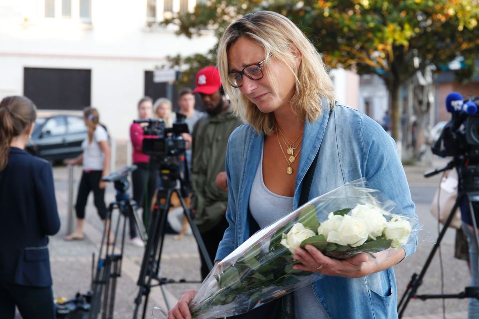  Country in mourning....a woman lays flowers at the city hall in the Normandy city of Rouvray