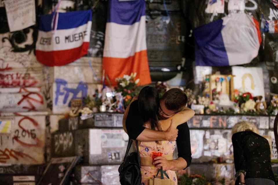  People stand in front of the place de la Republique's monument in Paris as France mourns yet another terror tragedy