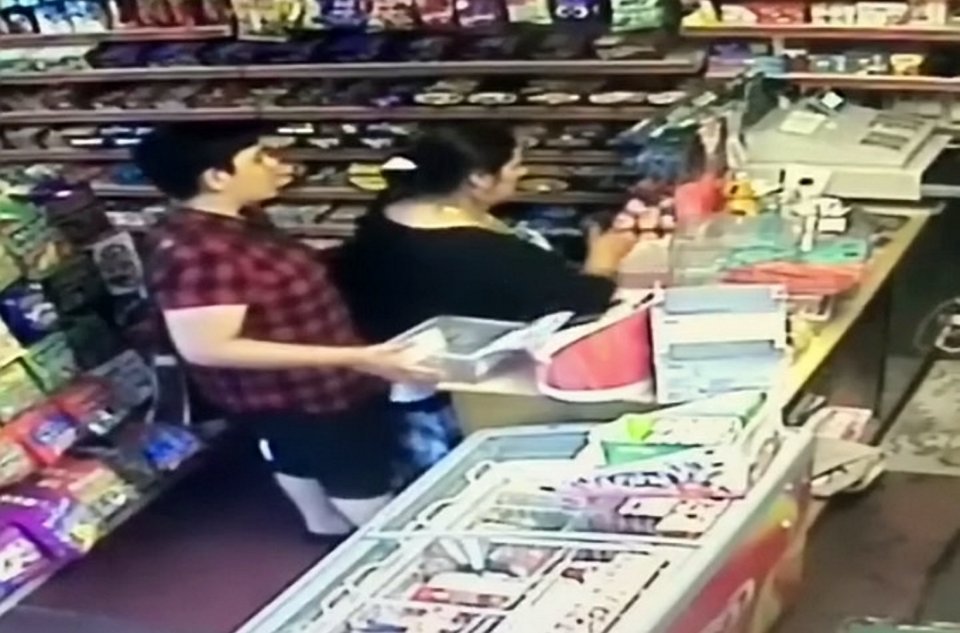 The woman can be seen leaning across to block the cashier's view