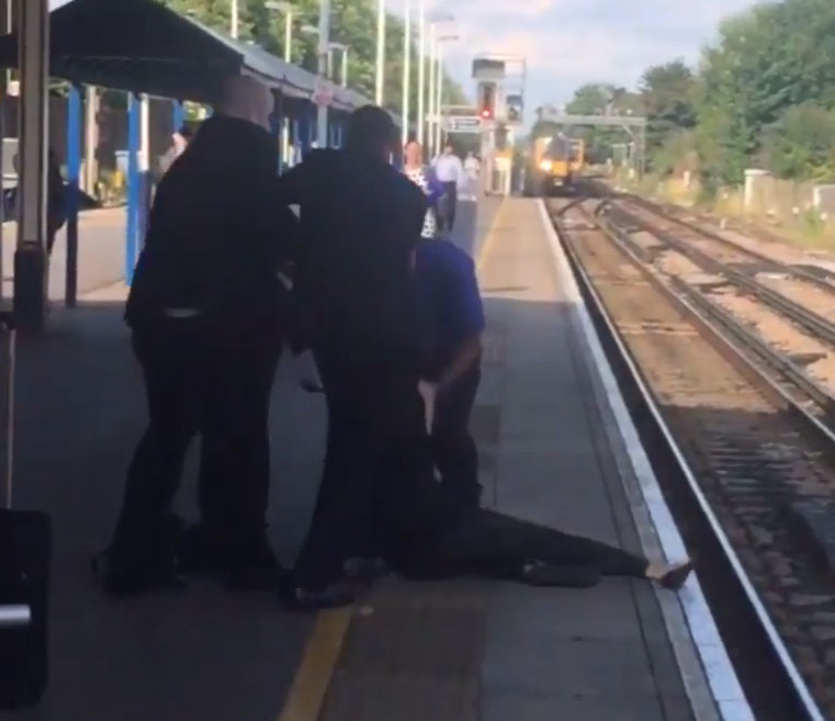  Close call... train approaches as the woman is dragged to the platform