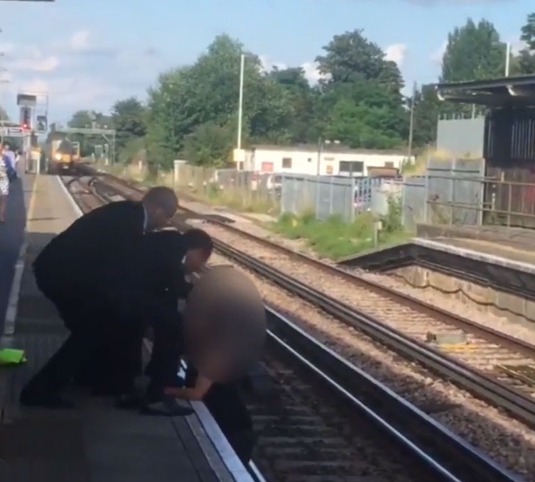  There is a mad scramble to pull the girl from the tracks as a train arrives