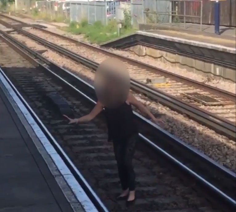  The girl stumbles across tracks as horrified staff look on