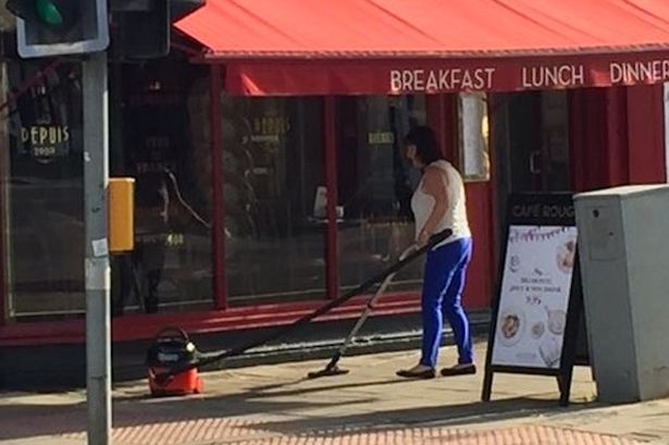  The woman was snapped vacuuming the pavement