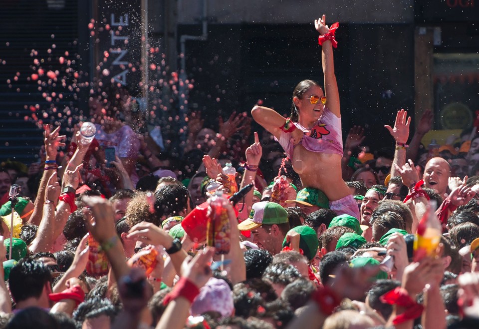  A woman exposes her nipples as people enjoy a tipple at the launch of northern Spain's world famous festival