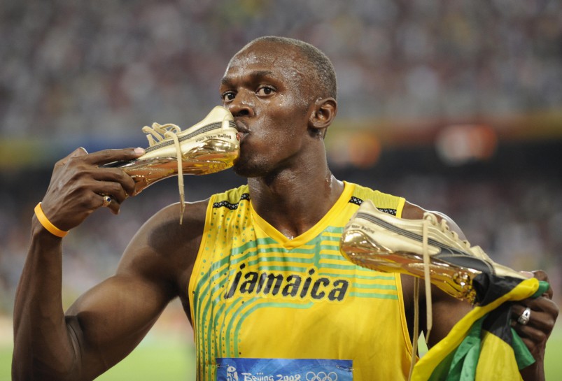 Jamaica's Usain Bolt kisses his shoe after winning the men's 100m final at the National stadium as part of the 2008 Beijing Olympic Games on August 16, 2008. Jamaica's Usain Bolt won the Olympic Games men's 100m gold medal on Saturday in a new world record time of 9.69sec. Trinidad and Tobago's Richard Thompson (9.89sec) and America's Walter Dix (9.91) took silver and bronze. AFP PHOTO / FABRICE COFFRINI (Photo credit should read FABRICE COFFRINI/AFP/Getty Images)