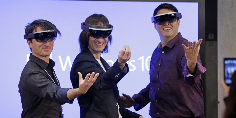  Microsoft's Joe Belfiore, from left, Alex Kipman, and Terry Myerson playfully pose for a photo while wearing Hololens devices in 2015