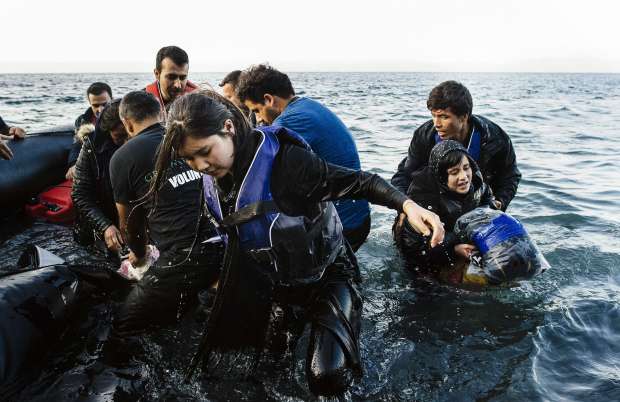 Refugees and migrants arrive on a rubber boat on the Greek island of Lesbos