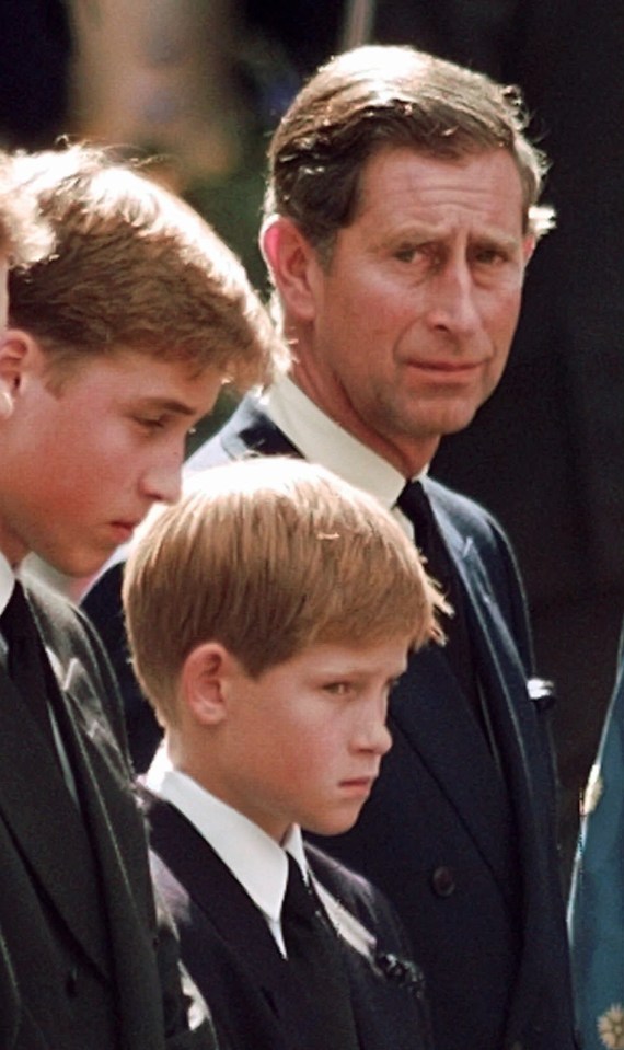 The Prince of Wales looks towards his sons Prince William and Prince Harry as they wait for the coffin of Princess Diana to be loaded into a hearse