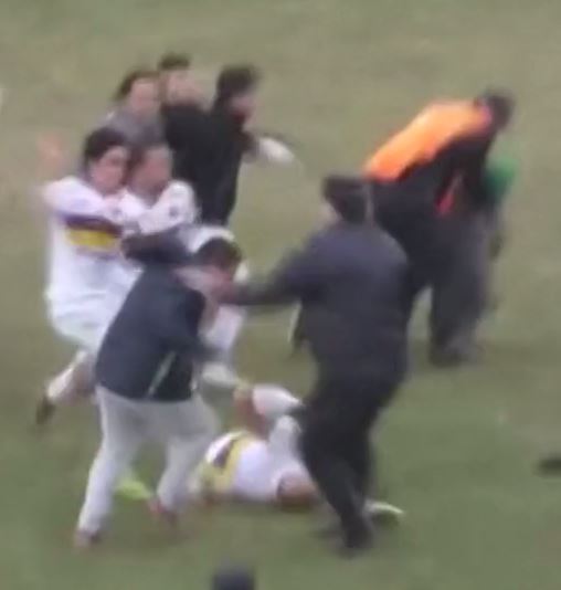  A Tiro player is punched by a Bella Vista supporter in the chaotic scenes