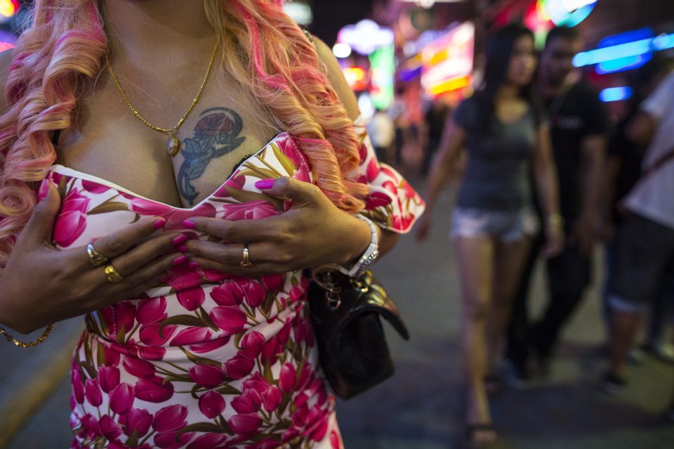  A Thai prostitute shows off her "goods" to passersby