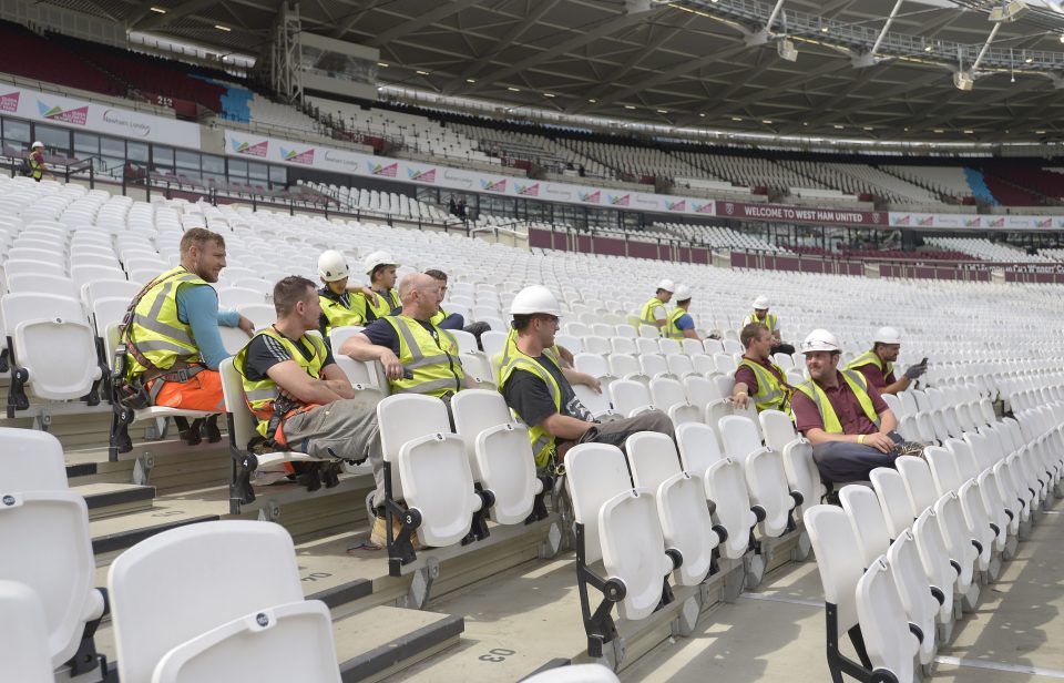  Builders watch the players train before adding the finishing touches