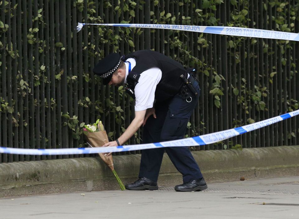  Tributes flood in ... police officer lays bouquet of fresh flowers at crime scene