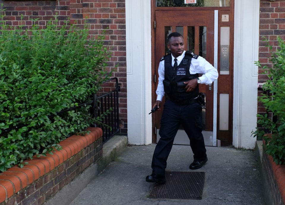  A police officer exits Bulham's Tooting home which is being searched by cops today