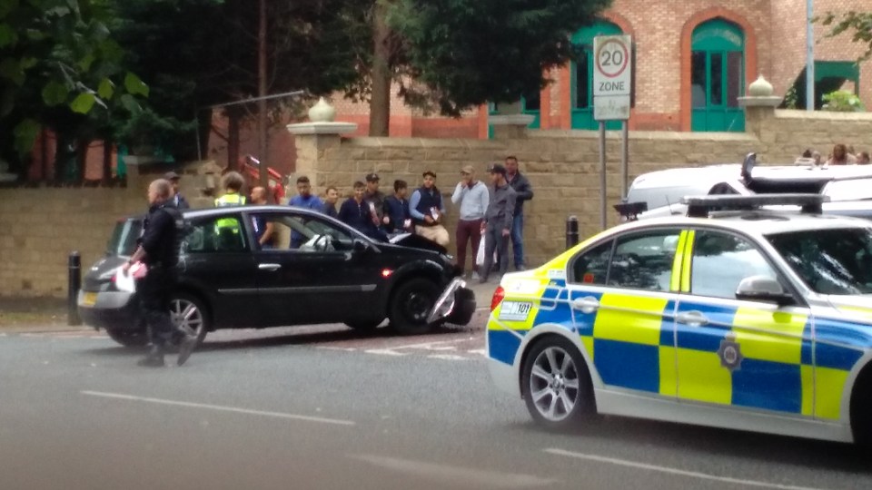  A crowd gathers as police clear up the scene of the police chase on Monday evening