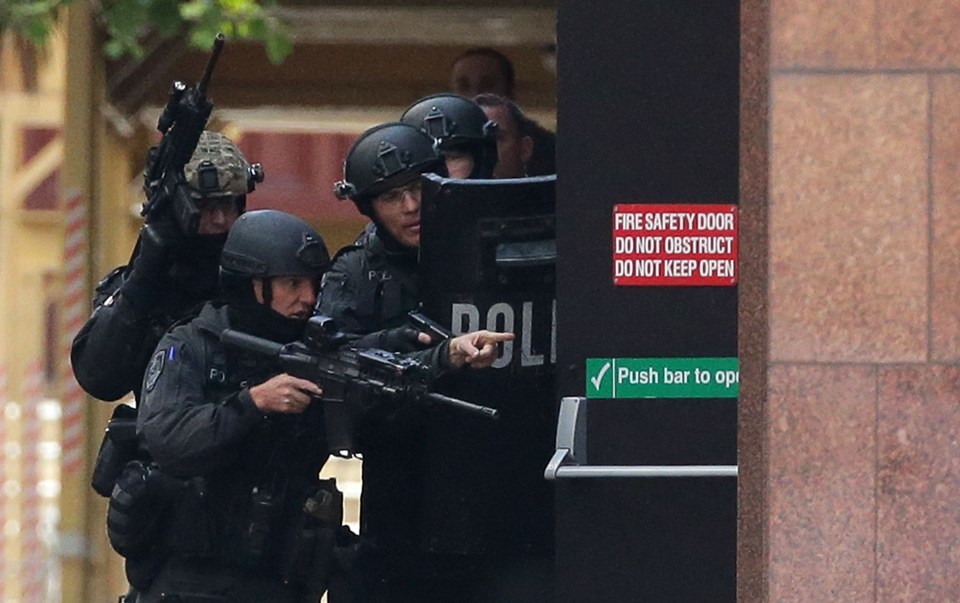  Armed police take guard near the cafe in downtown Sydney during the siege