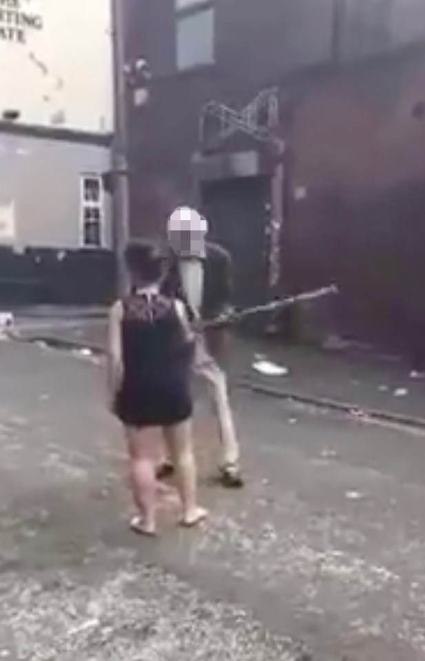  The elderly man raises his walking stick and whacks her during the confrontation