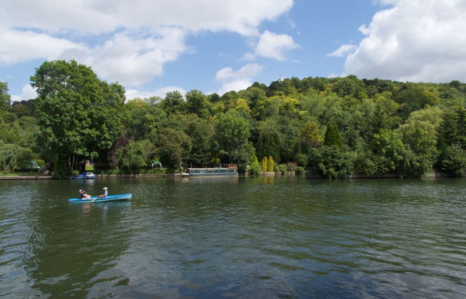  A pair enjoying rowing down the calm river in Henley, Oxford, with lush greenery either side