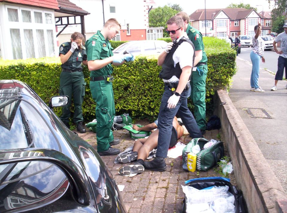  The victim lies bleeding after he was chased by a gang and stabbed in a front garden in a residential street in Wembley, North West London