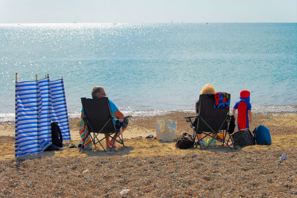  A seat with a view: A couple relax on the sand and enjoy the calming influence of the sea