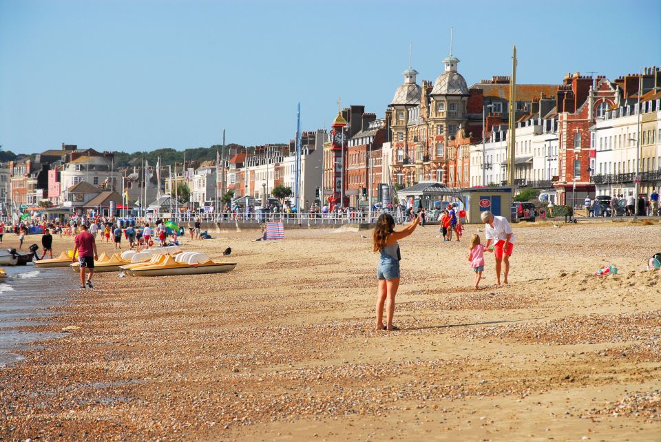  Life's a beach: A woman takes the time to snap a selfie in Weymouth, Dorset