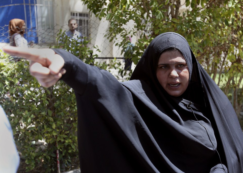  A woman speaks to media as she waits for the body of her newborn baby