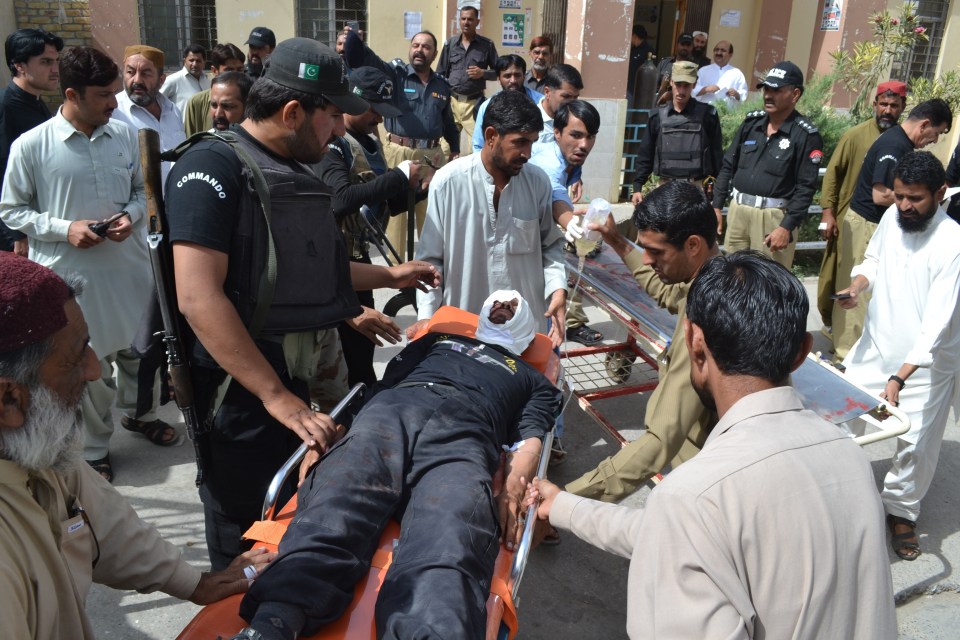  Pakistani security officials rush their injured colleague to a hospital in Quetta after a roadside bomb exploded