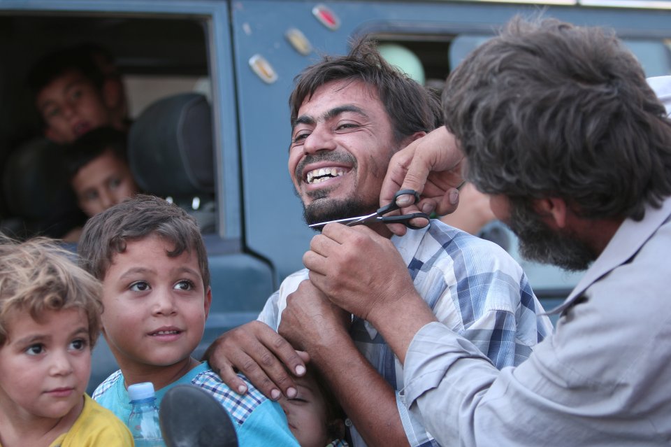  A delighted man cuts his beard after being governed by strict ISIS thugs for two years