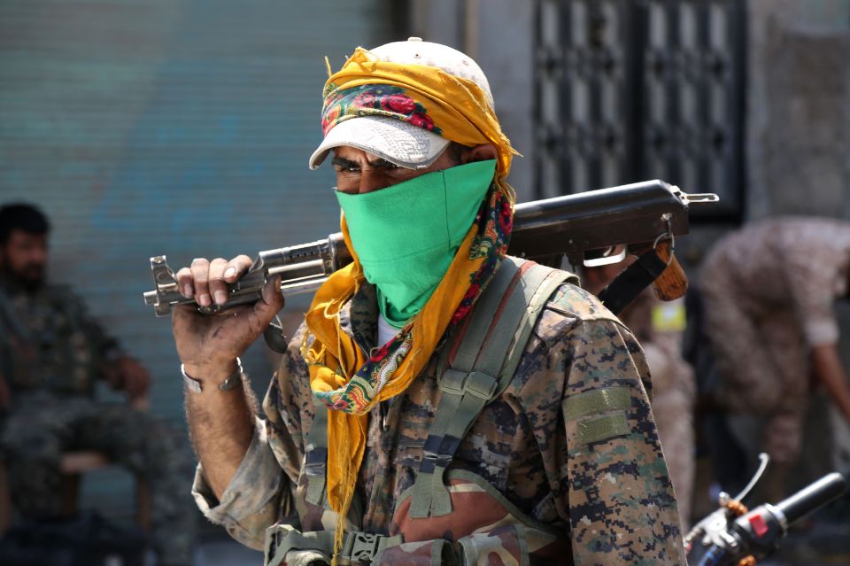  Striking . . . fighter in bright bandana poses after liberating city